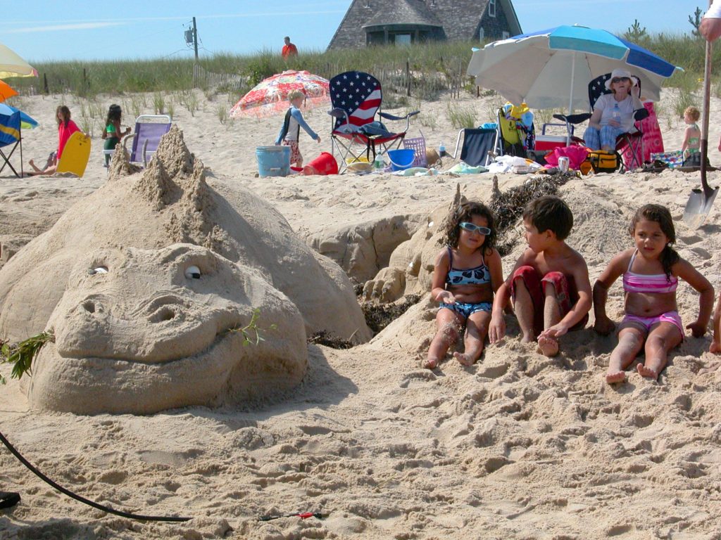 Youngsters enjoying a sand castle building content on the beach in East Hampton