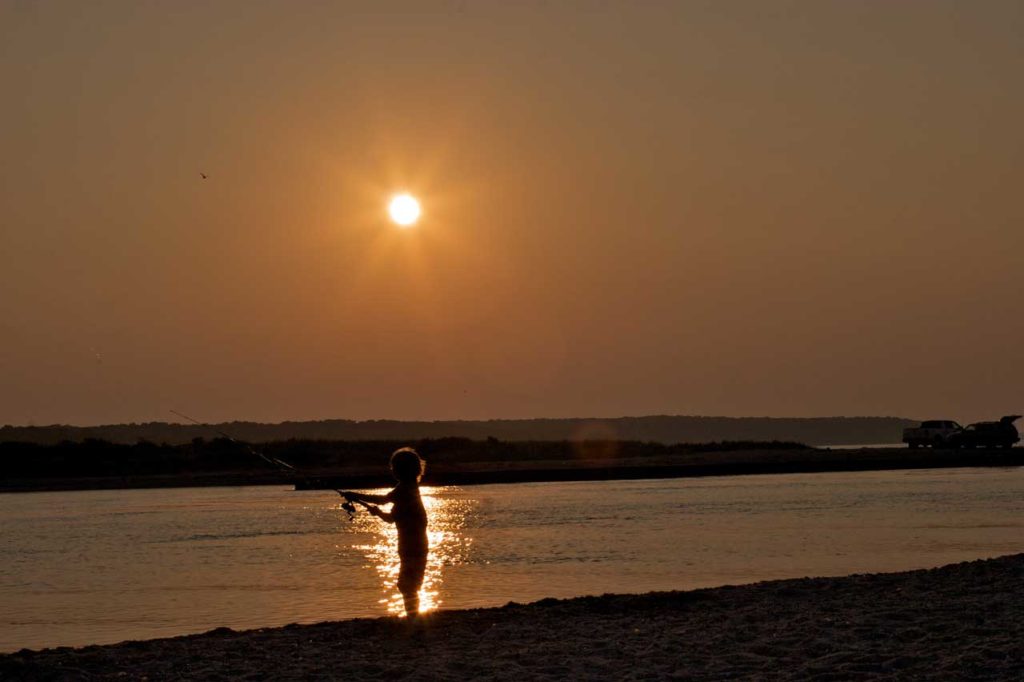 Image of a child fishing at maidstone at sunset