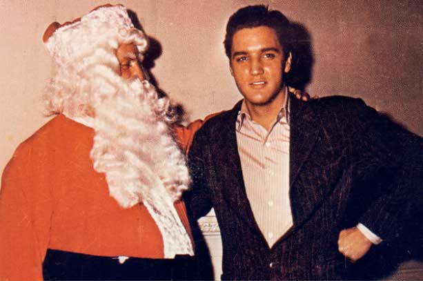 Elvis Presley poses with Colonel Tom Parker dressed as Santa Claus in this Christmas card circa 1965